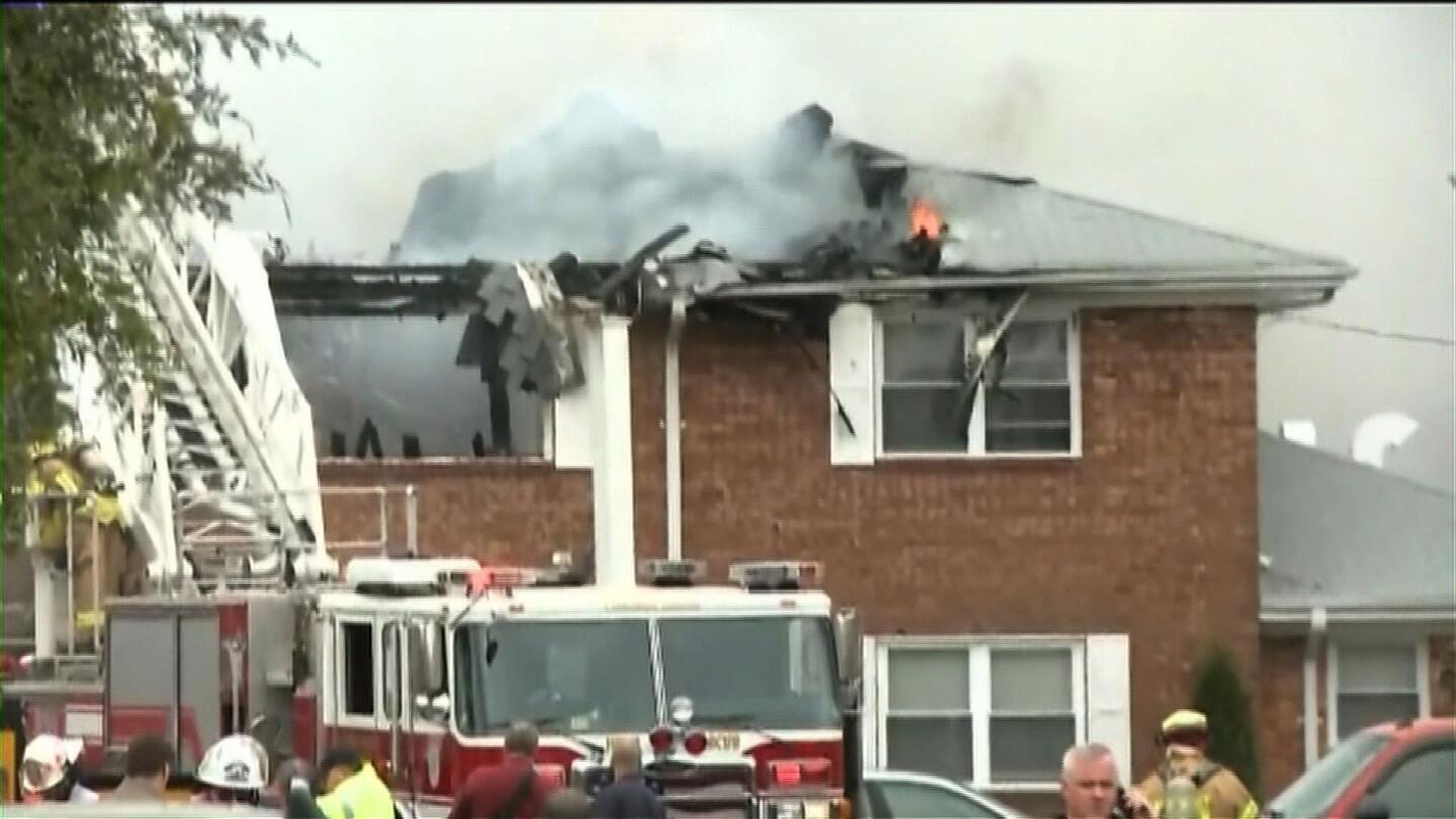Firefighters trying to contain a blaze after a Navy F/A-18 Hornet crashed into an apartment building in Virginia Beach, Va.