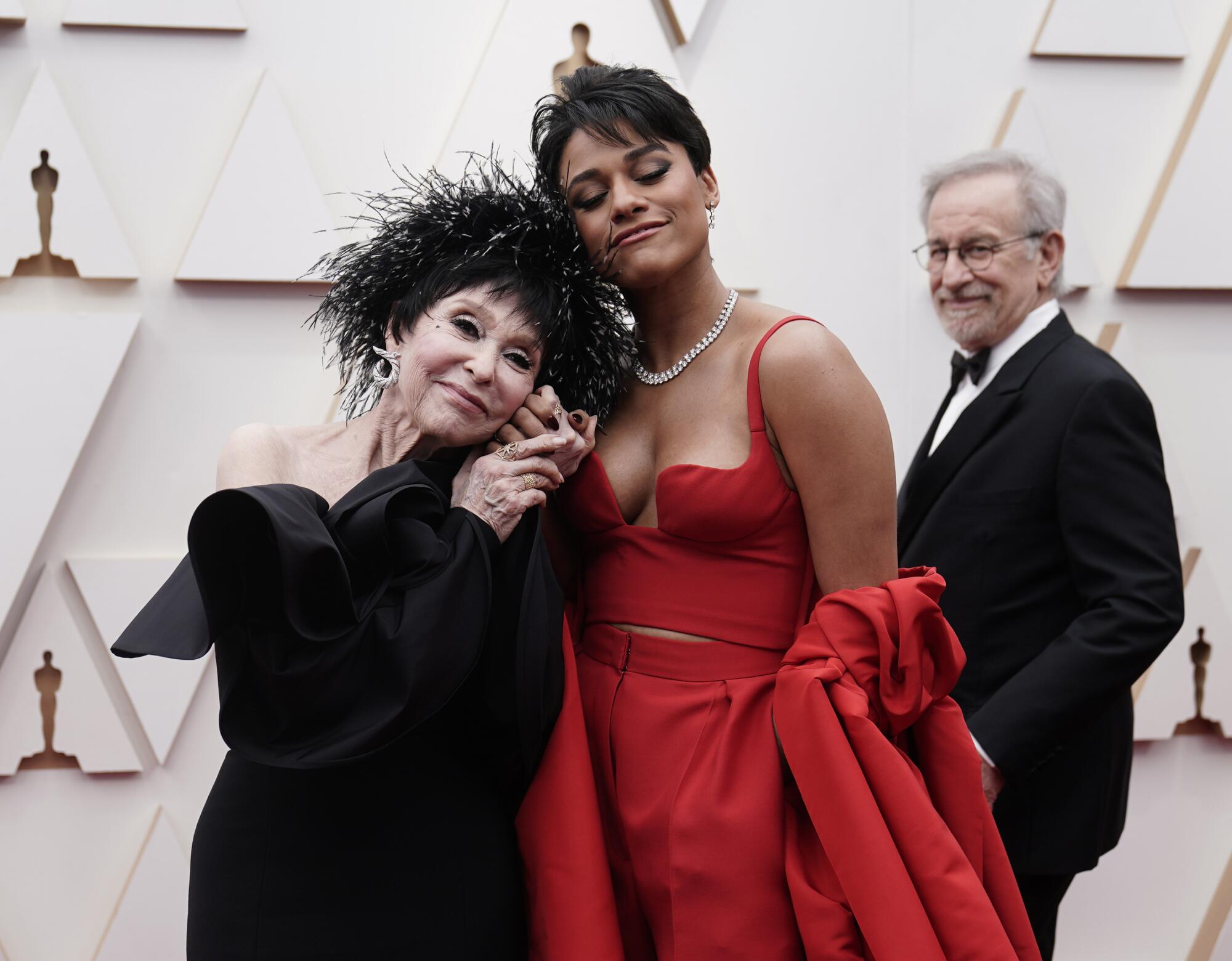 Rita Moreno, izquierda, y Ariana DeBose llegan a los Oscar. Al fondo mira Steven Spielberg.