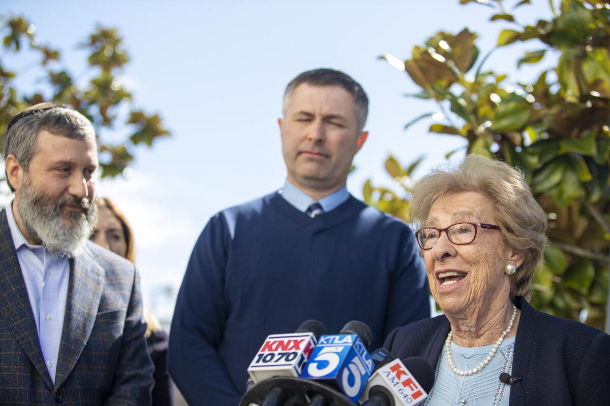 Eva Schloss, a Holocaust survivor and Anne Frank's stepsister, joins Newport Harbor High School Principal Sean Boulton, center, and Rabbi Reuven Mintz of the Chabad Center for Jewish Life in Newport Beach during a news conference in March after Schloss met with students involved in an off-campus party where local teenagers were photographed making Nazi salutes around a makeshift swastika.