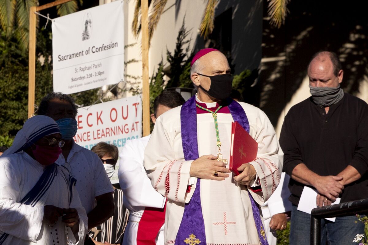 San Francisco's Archbishop Salvatore Cordileone in robes stands in front of a church with other people