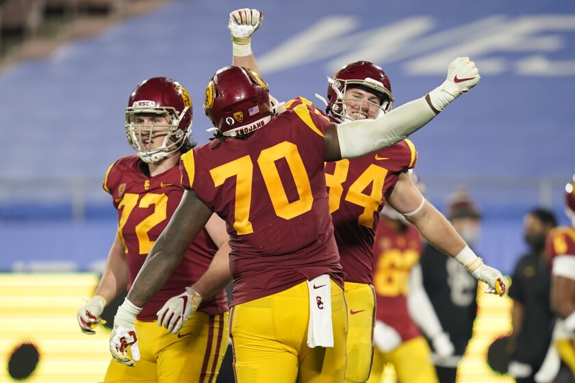 USC offensive linemen Andrew Vorhees and Jalen McKenzie and tight end Erik Krommenhoek celebrate a fourth-quarter touchdown.