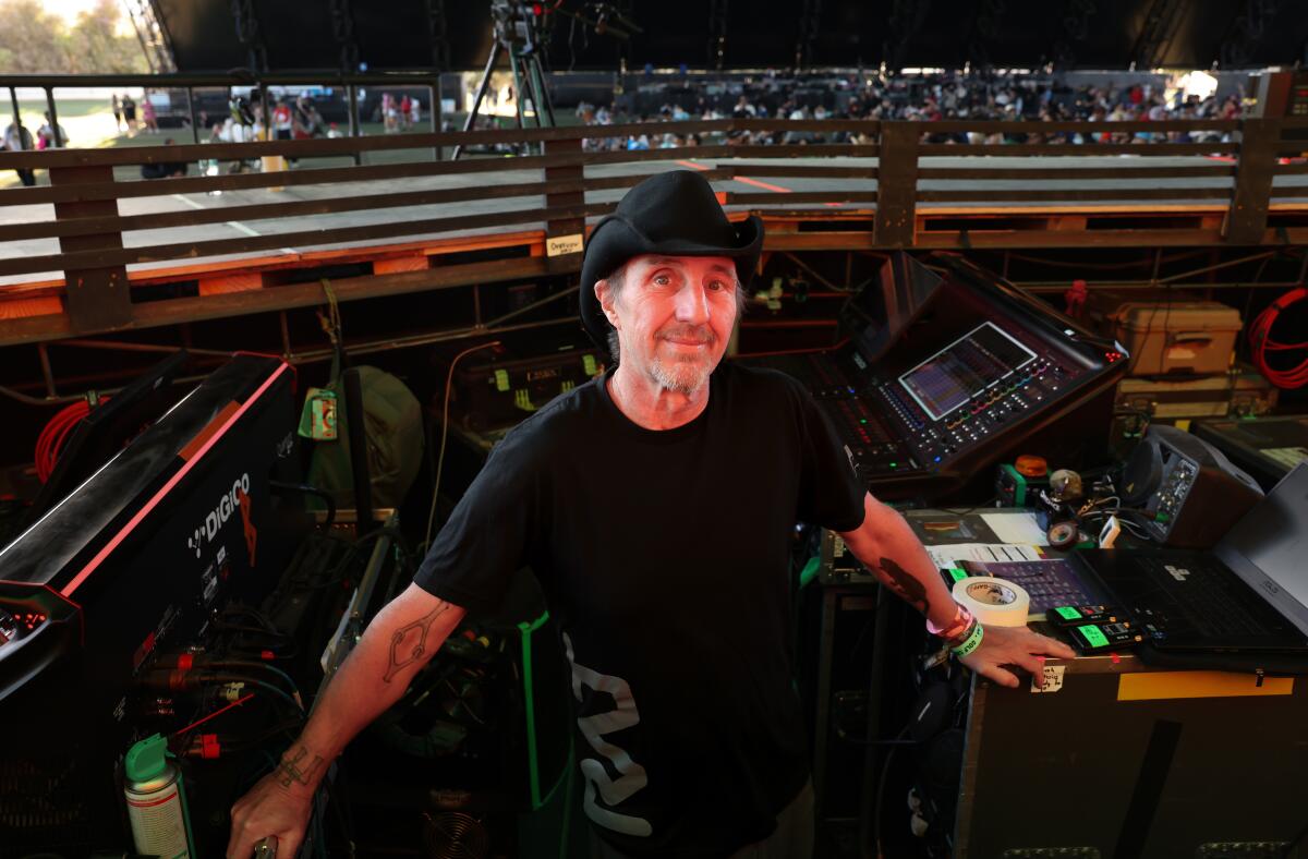 Man in black cowboy hat and shirt handling the soundboard at Coachella