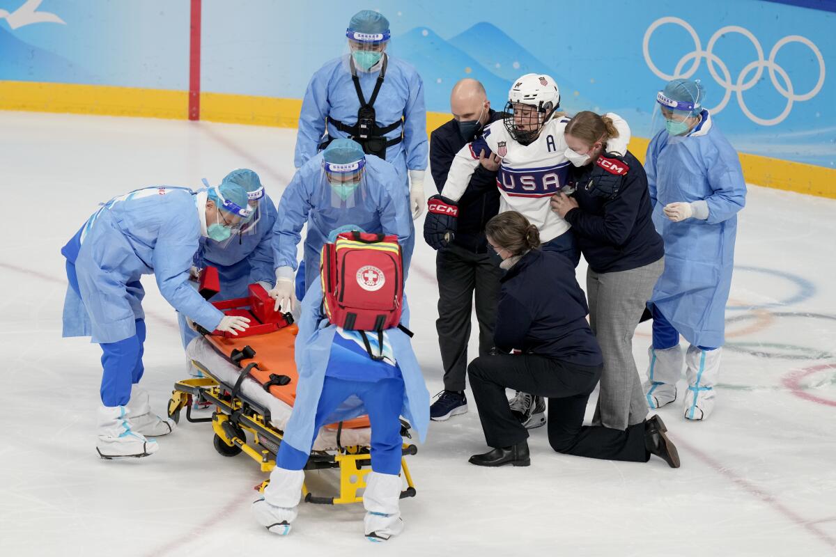 Hockey player Brianna Decker is helped off the ice at the 2022 Olympics.
