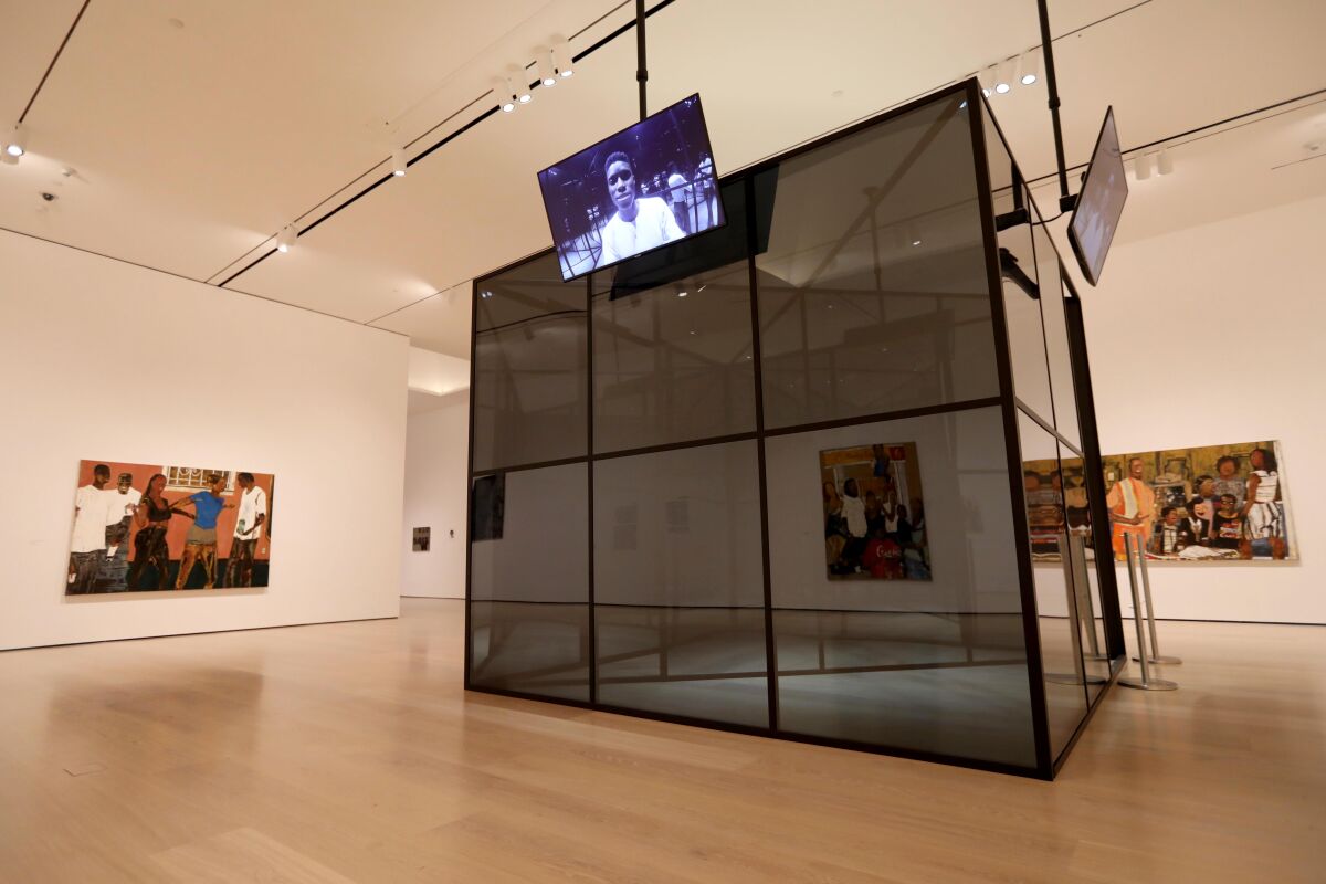 Brandon D. Landers' paintings surround Aria Dean's video performance "production cube."