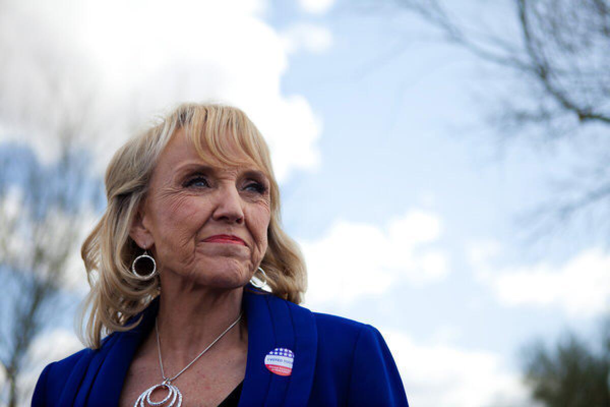 Arizona Gov. Jan Brewer talks to the news media after voting in the Republican presidential primary.