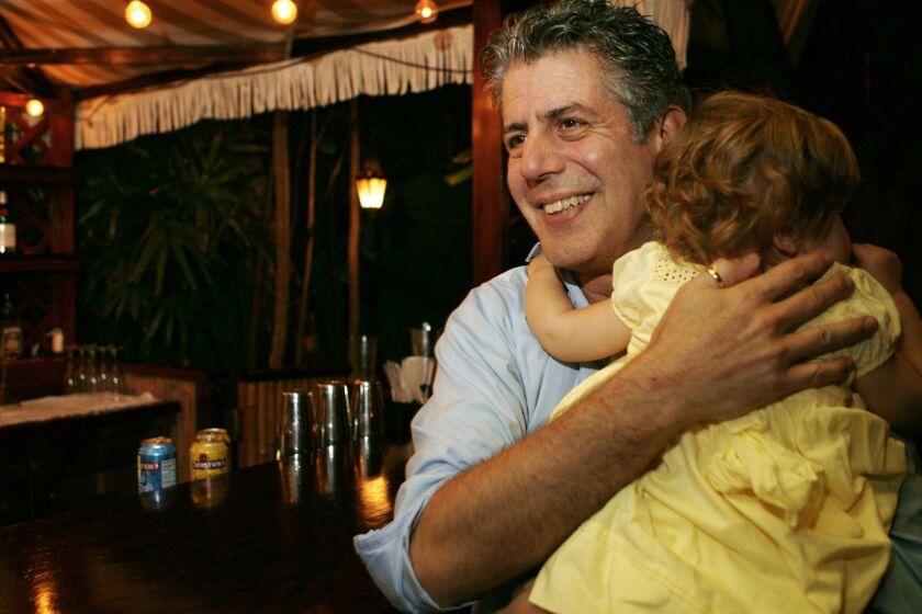 FILE - In this Nov. 12, 2008 file photo, Chef Anthony Bourdain holds his daughter Ariane in Miami Beach. Court papers show that Bourdain was worth $1.2 million when he died last month. Most of the estate has been left to his daughter, who is now 11-years-old. Bourdain was found dead June 8 in an apparent suicide in his French hotel room while working on his CNN series "Parts Unknown." (AP Photo/Lynne Sladky, File)