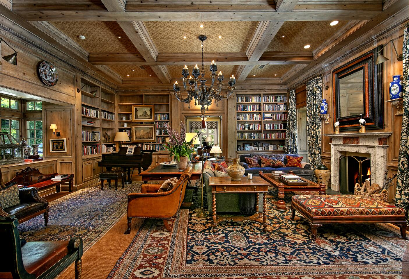 Living room with a fireplace, furniture and filled bookshelves.