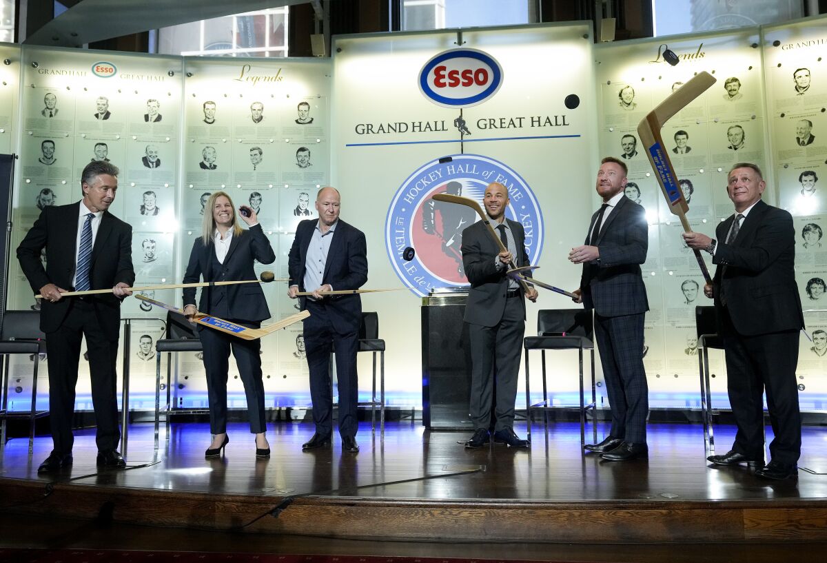 Hockey Hall of Fame inductees, from left, Doug Wilson, Kim St-Pierre, Kevin Lowe, Jarome Iginla, Marian Hossa and Ken Holland pose for a photograph in Toronto, Friday, Nov. 12, 2021. (Nathan Denette/The Canadian Press via AP)