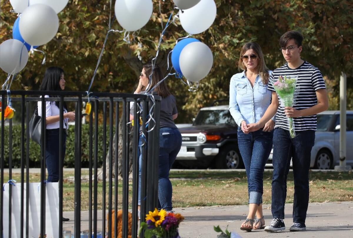 Estudiantes de la preparatoria se acercan al lugar a colocar flores y veladoras en memoria de las víctimas en Santa Clarita.