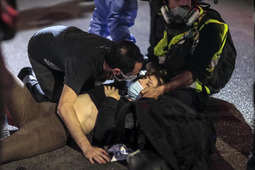 Los Angeles, CA, Thursday, September 24, 2020 - A victim is comforted after being hit by a hit and run driver on Sunset Blvd. as she was protesting the Kentucky grand jury decision in the case of Breonna Taylor's death by Louisville police. (Robert Gauthier/ Los Angeles Times)