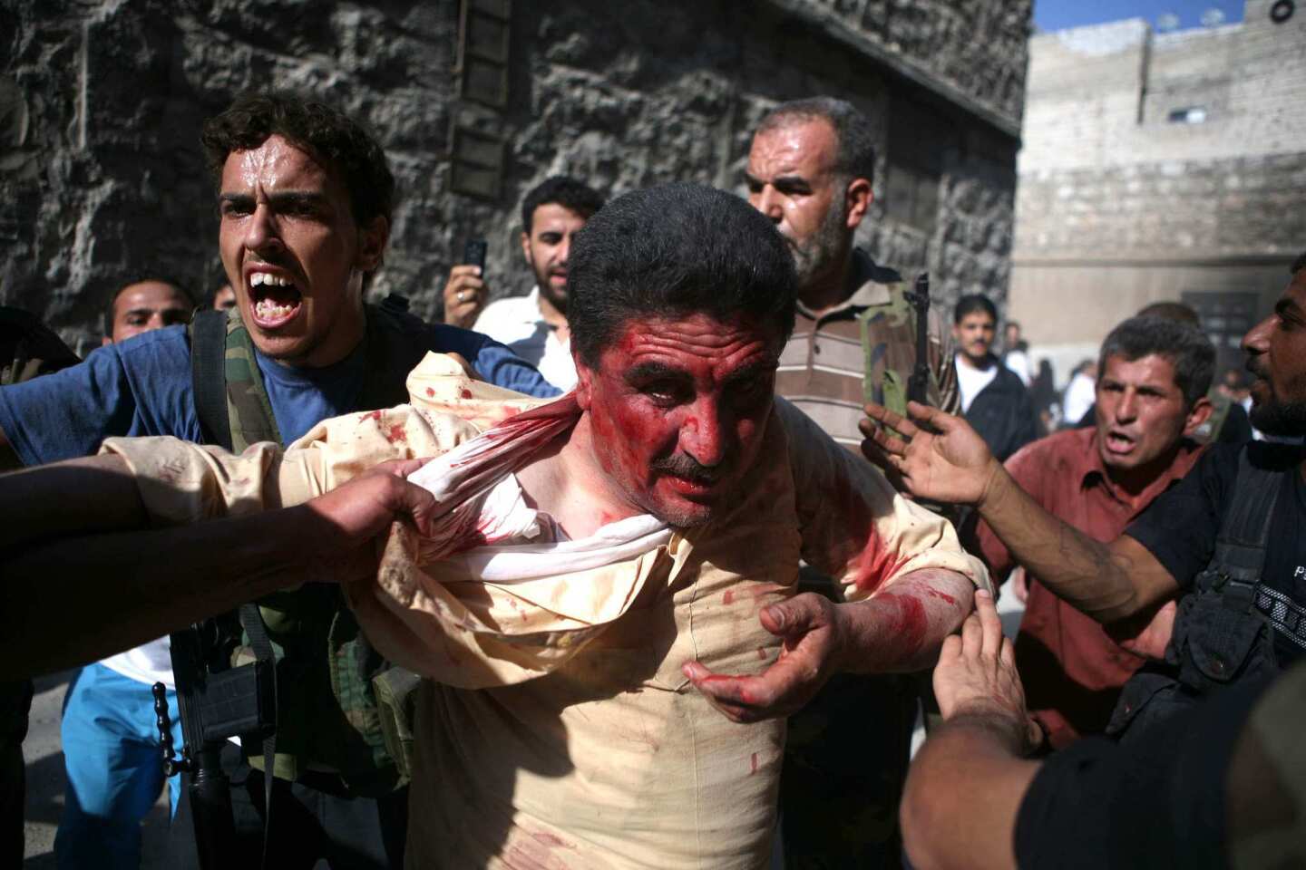 Rebel Free Syrian Army (FSA) fighters capture a policeman who the FSA allege was a pro-regime militiaman, as the rebels overran a police station in Aleppo.