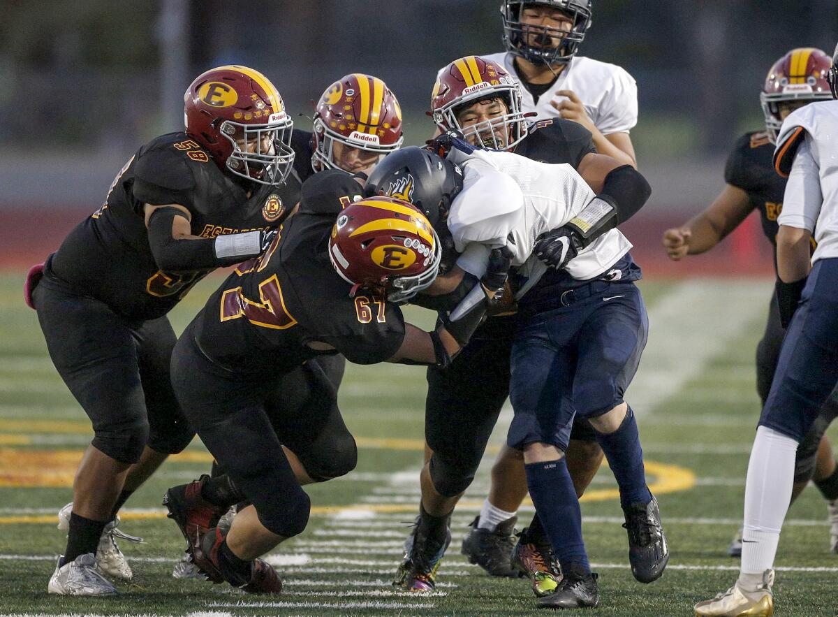 Estancia's Steve Sanchez (58), Ryan Carrasco (67), Jorge Cortinas and Julian Muro (42), bring down La Quinta's Alex Tran.