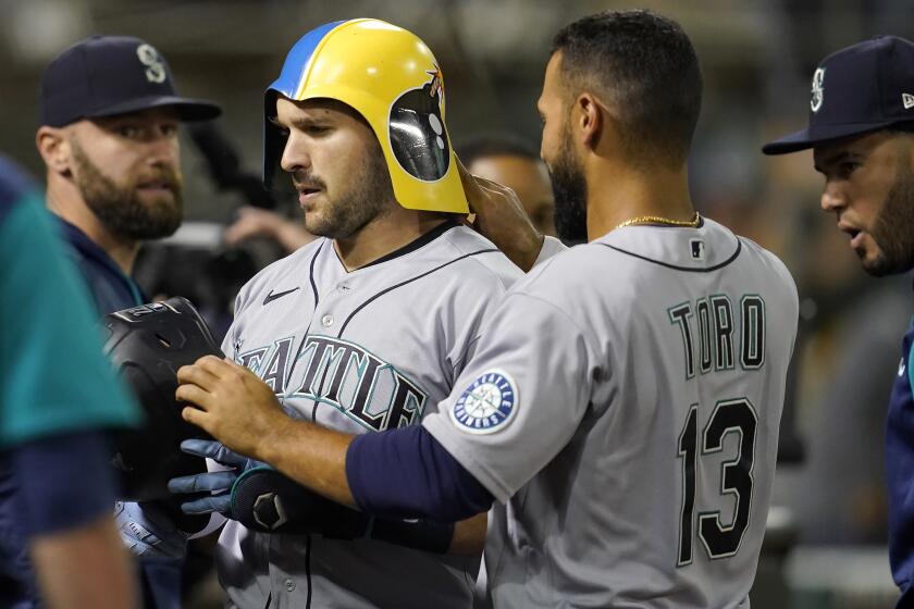 El venezolano Luis Torrens, de los Marineros de Seattle, recibe la felicitación de su compatriota Abraham Toro, luego de conectar un jonrón ante los Atléticos de Oakland, el miércoles 21 de septiembre de 2022 (AP Foto/Jeff Chiu)