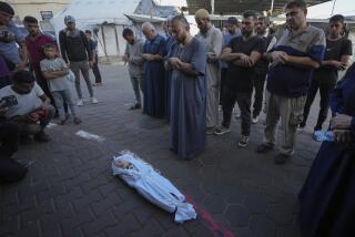 Mourners pray over the body of a Palestinian child, Hosam Al Khaldi, killed in the Israeli bombardment of the Gaza Strip outside the hospital morgue in Deir al-Balah on Wednesday, Oct. 9, 2024. (AP Photo/Abdel Kareem Hana)