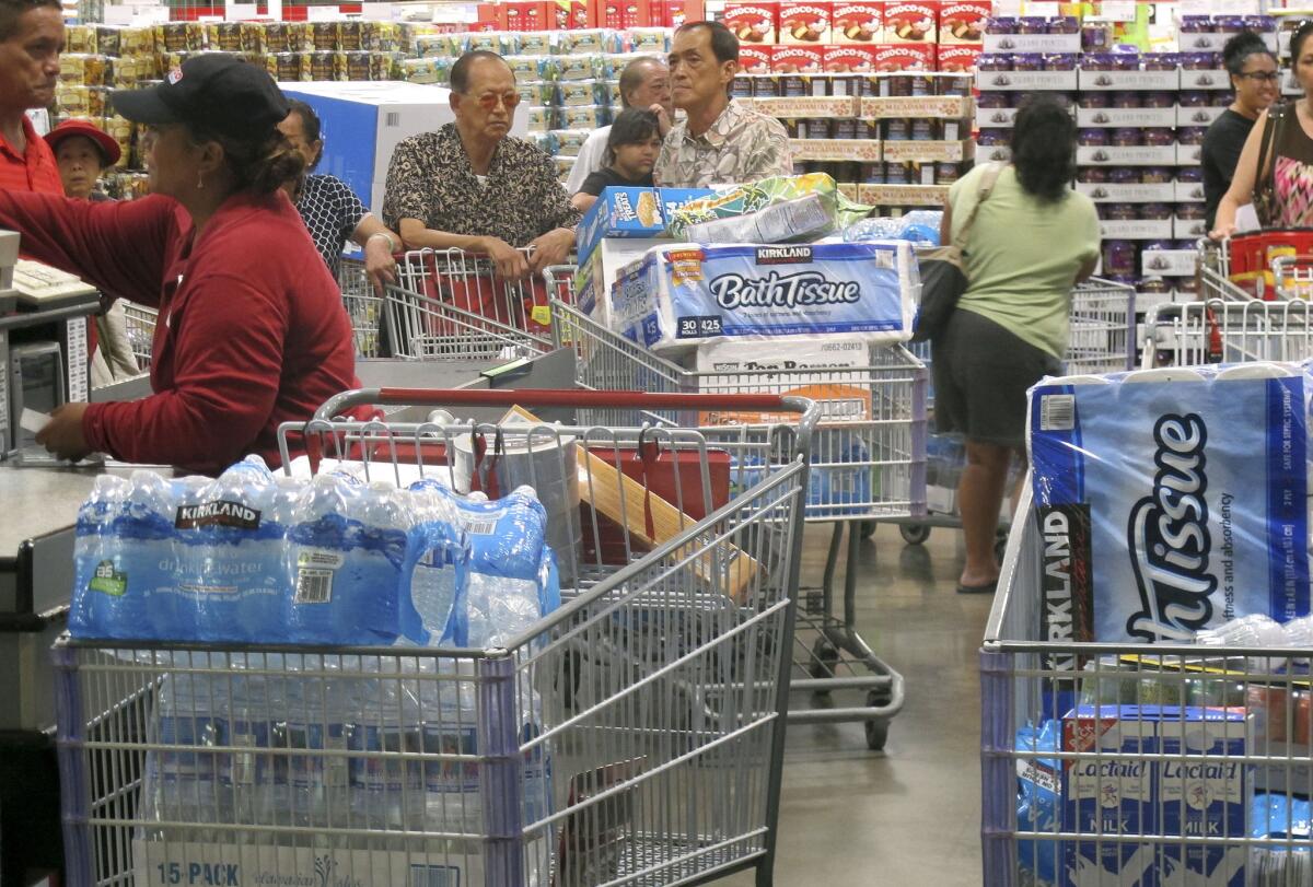 Shoppers at the Iwilei Costco in Honolulu stock up on cases of bottled water and other supplies in preparation for Hurricane Iselle and Tropical Storm Julio. The storms are predicted to start hitting Thursday or Friday.