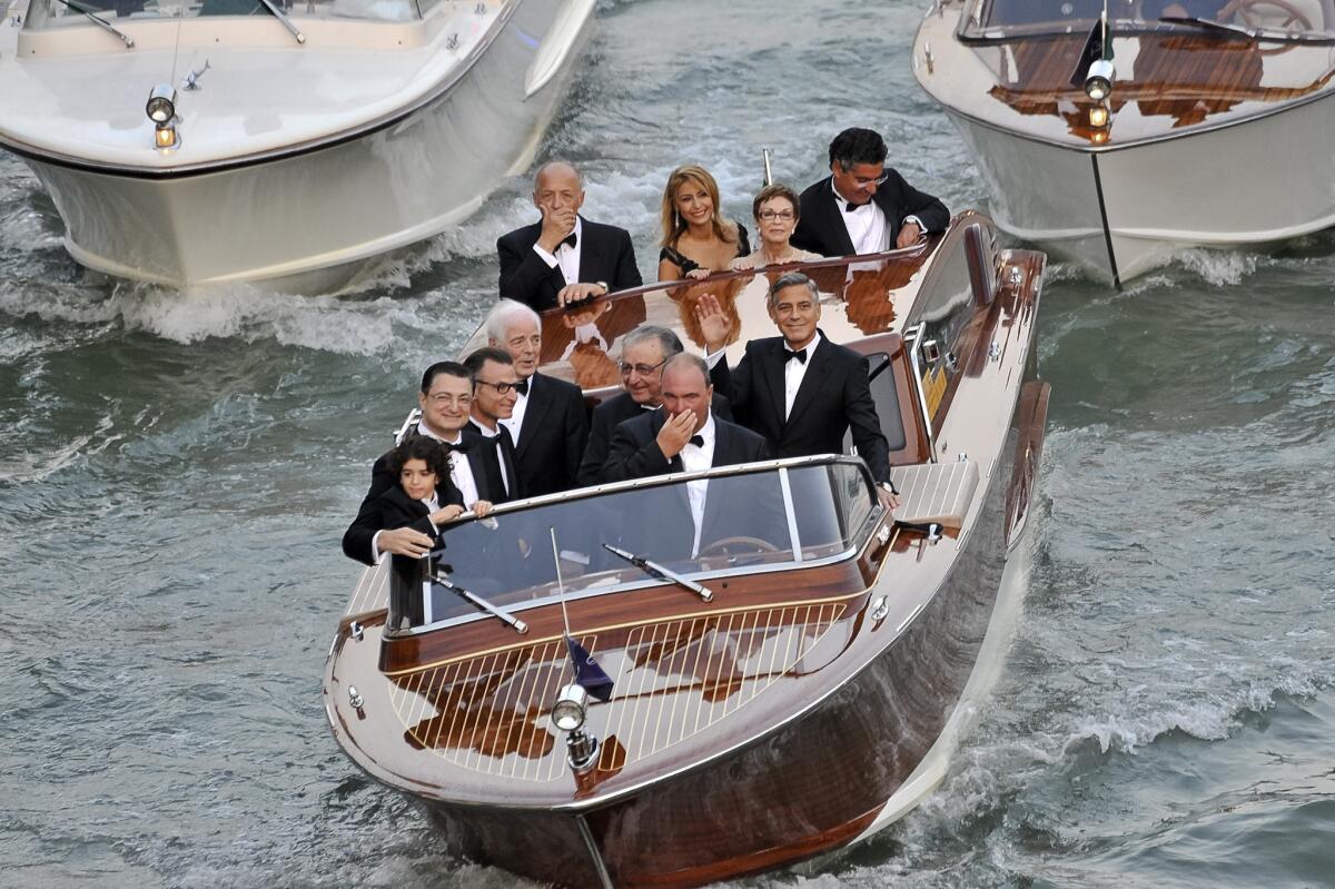 Actor George Clooney, waving, right, with family and friends on his way to get married in Venice, Italy.