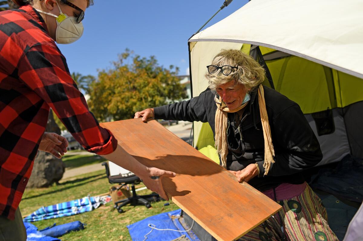 David Busch-Lilly gets help moving out of his tent in Echo Park Tuesday. 