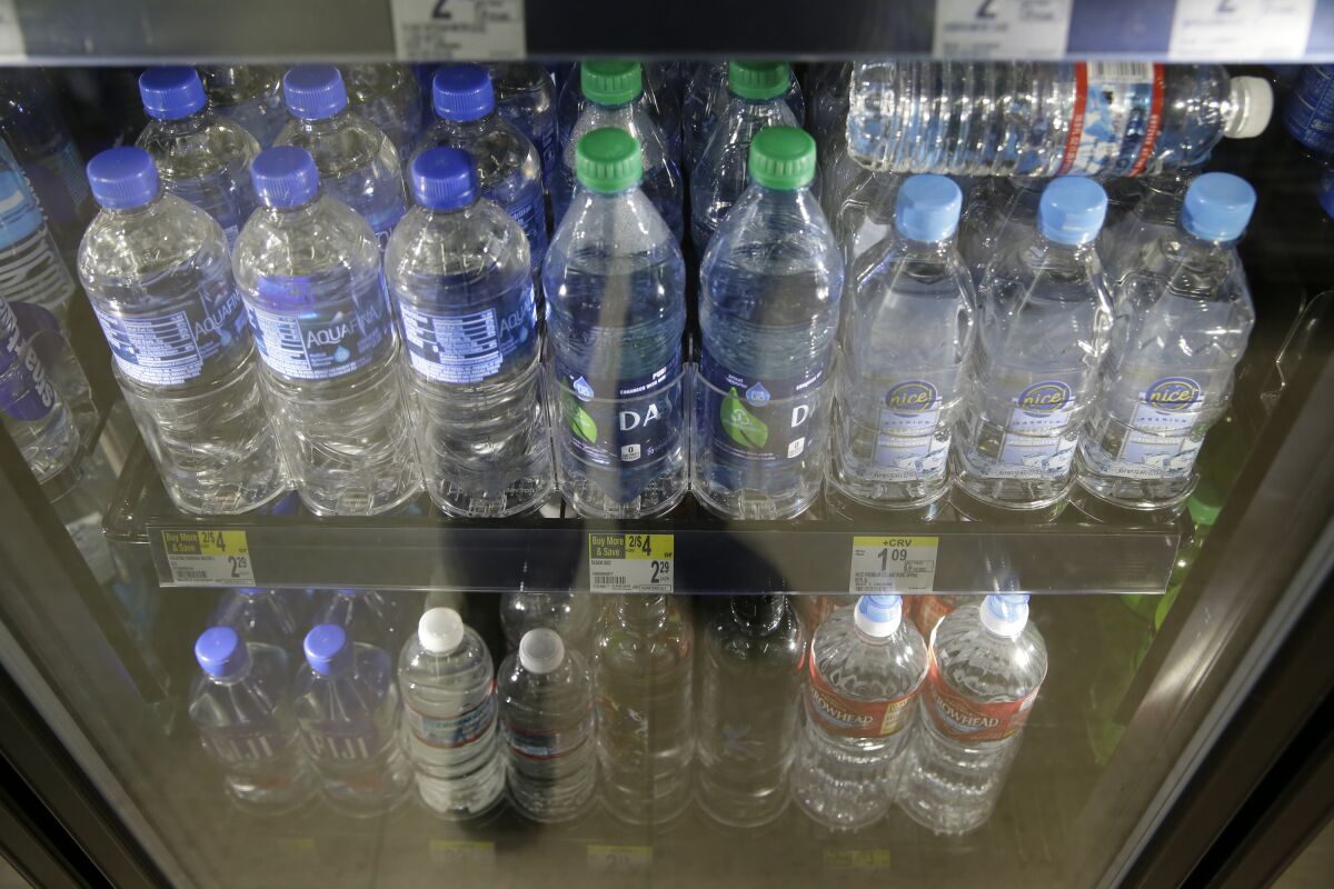Varieties of bottled water in a refrigerator.