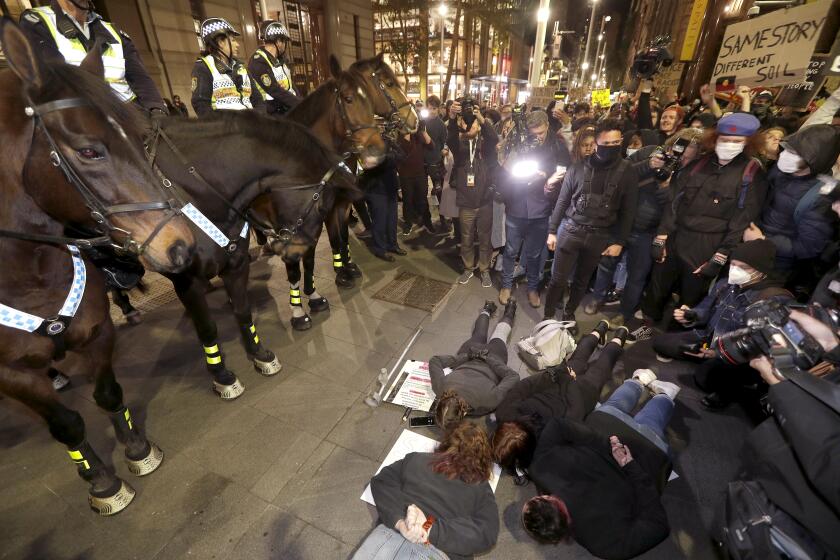 Protestors lay on the ground in front of police on horseback as they gather in Sydney, Tuesday, June 2, 2020, to support the cause of U.S. protests over the death of George Floyd and urged their own governments to address racism and police violence. Floyd died last week after he was pinned to the pavement by a white police officer who put his knee on the handcuffed black man’s neck until he stopped breathing. (AP Photo/Rick Rycroft)