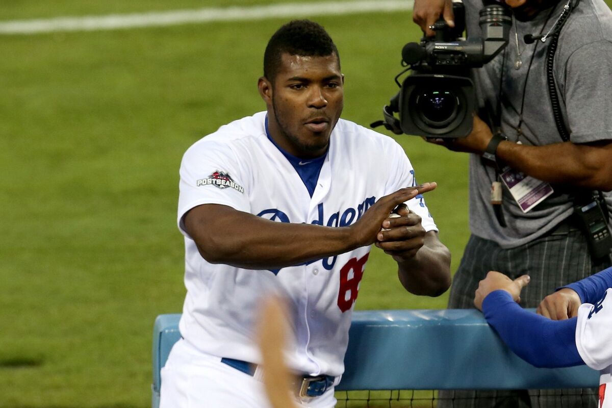 Dodgers outfielder Yasiel Puig warms up a ball for a fan during the National League Division Series in October.