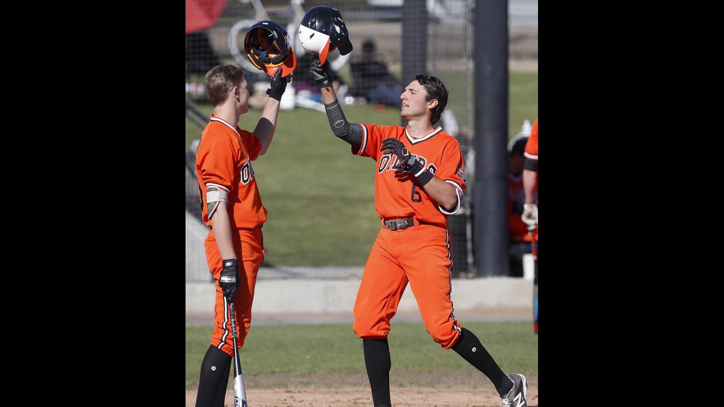 Huntington Beach High's Brett Barrera, right, celebrates his solo homer with teammate Jag Burden, left, against Fountain Valley during the second inning in a Surf League game at Huntington Beach High on Friday, March 15, 2019.