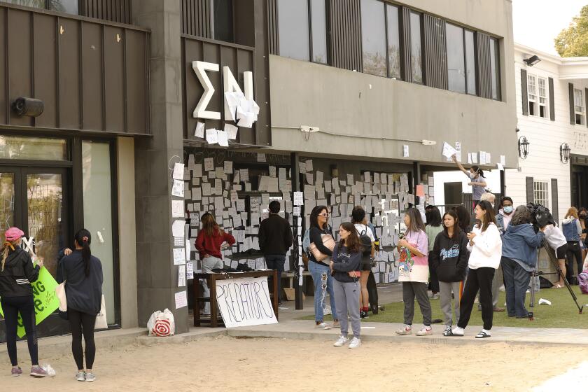 LOS ANGELES, CA - OCTOBER 22: USC students gather Friday afternoon at the Sigma Nu fraternity house near the USC campus. USC officials have placed the Sigma Nu fraternity chapter on interim suspension following allegations that women were drugged and sexually assaulted at the fraternity house. In a crime alert issued Thursday, the USC Department of Public Safety said campus officials received "a report of sexual assault" at the Sigma Nu fraternity house locate at 660 W. 28th St. "The university also has received reports of drugs being placed into drinks during a party at the same fraternity house, leading to possible drug-facilitated sexual assaults," according to the alert. USC on Friday, Oct. 22, 2021 in Los Angeles, CA. (Al Seib / Los Angeles Times).