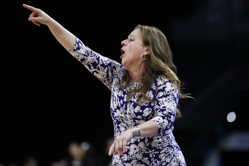 UCLA head coach Cori Close motions towards the court during the first half of an NCAA college.