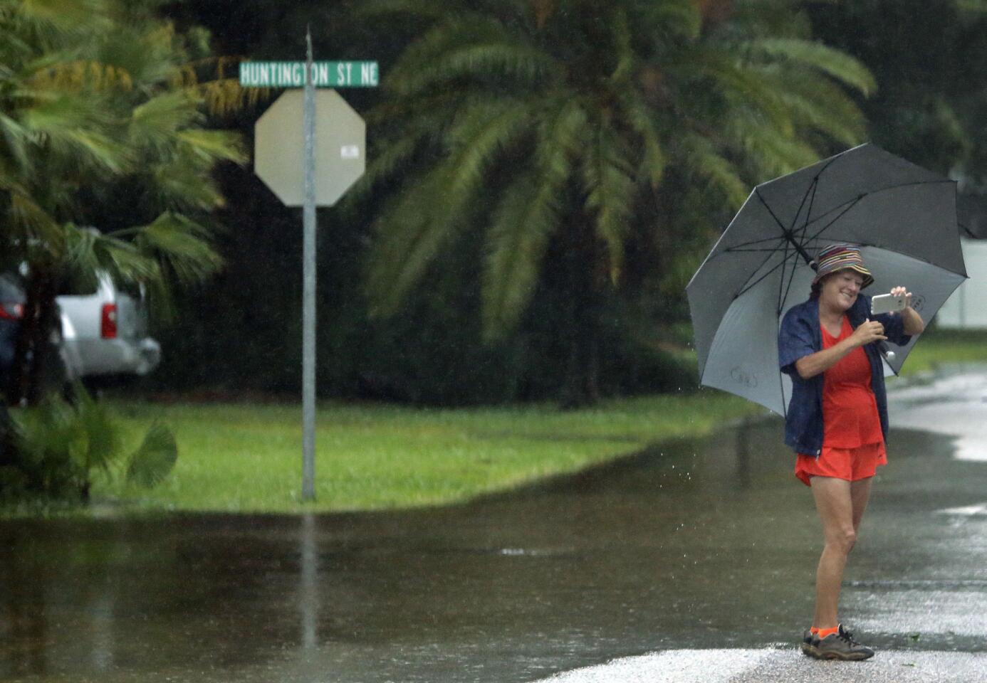 A woman takes a photo of flooded streets in the Shore Acres in St. Petersburg, Fla., Tuesday, June 7, 2016. Remnants of Tropical Storm Colin was continued to dump rain along Florida's gulf coast Tuesday.