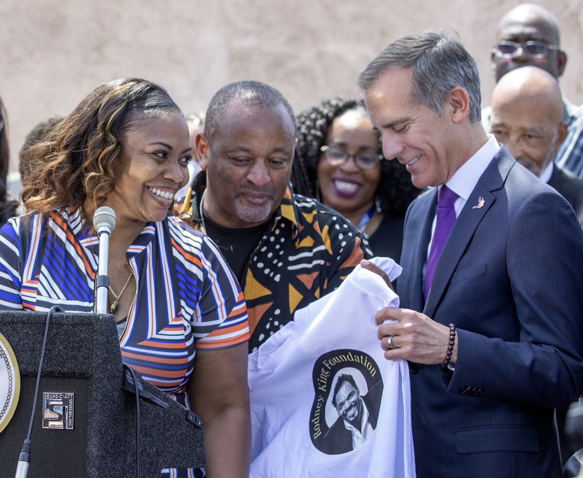 Los Angeles Mayor Eric Garcetti reacts after being given a shirt with an image of Rodney King on it.