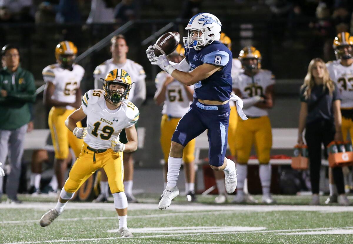Corona del Mar's Ryder Haupt (8) intercepts a pass intended for Edison's Troy Fletcher (19) in a Sunset League game at Newport Harbor High on Friday.