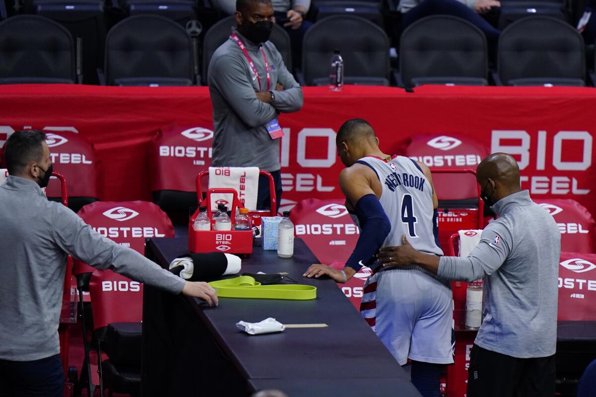 Washington Wizards' Russell Westbrook (4) is helped to the locker room after an injury.