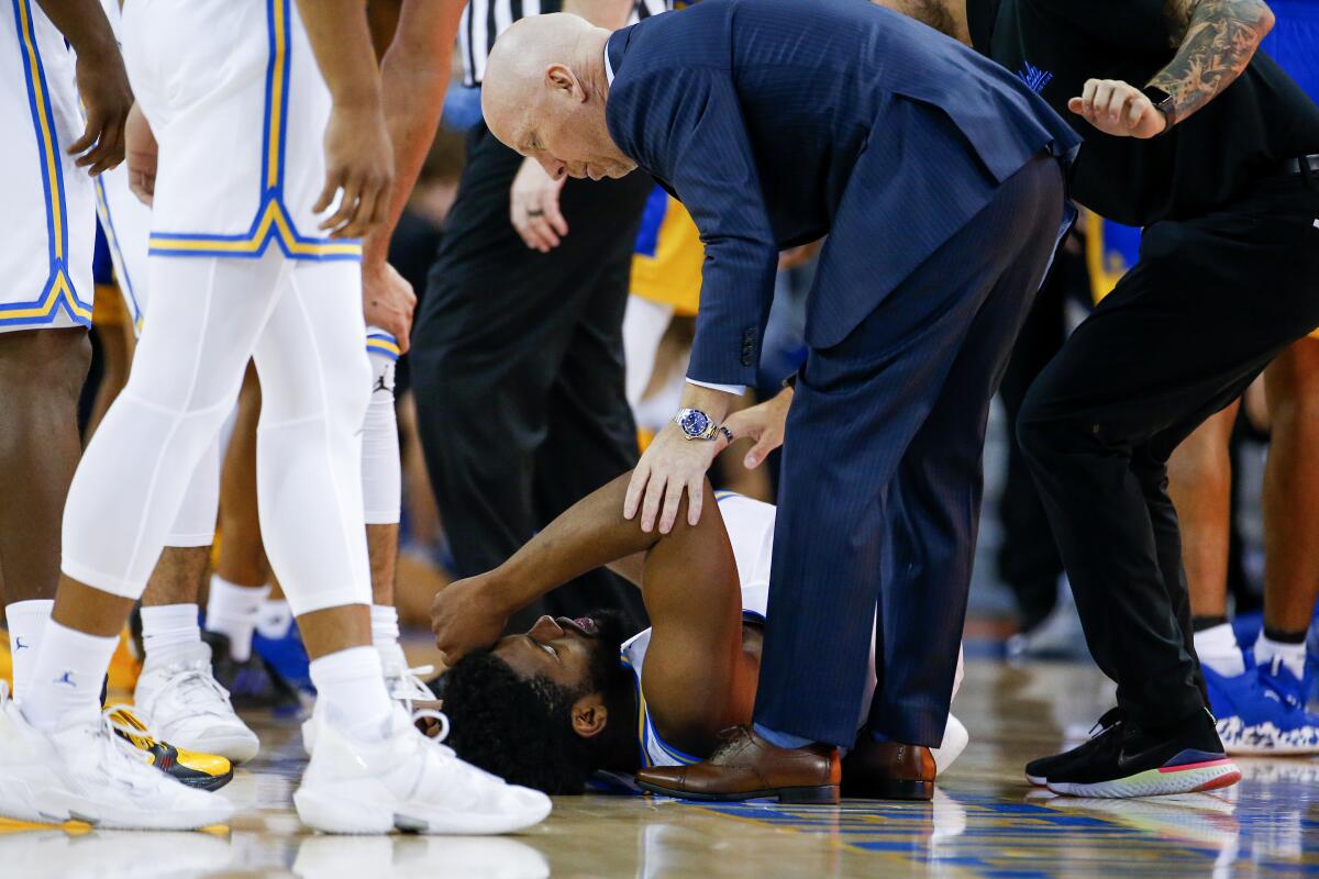 UCLA coach Mick Cronin checks on forward Cody Riley, who is on the floor after getting injured Tuesday