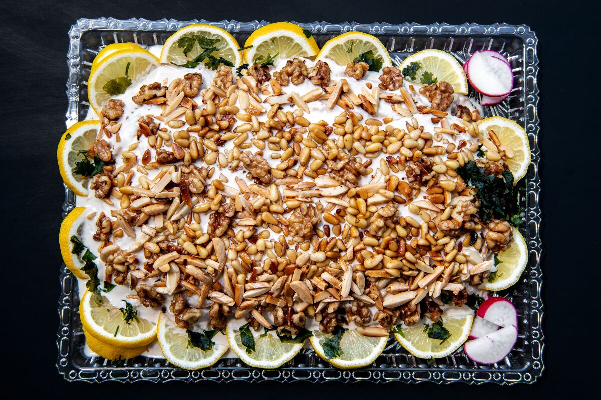 Swai fish stuffed with spices and crushed walnuts, covered with tahini sauce and topped with toasted pine nuts and walnuts