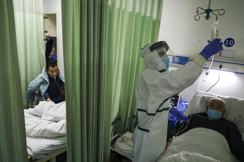 En esta imagen del jueves 6 de febrero de 2020, una enfermera comprueba el estado de un paciente en un ala de aislamiento para pacientes del 2019-nCoV en un hospital de Wuhan, en la provincia china de Hubei. (Chinatopix via AP)