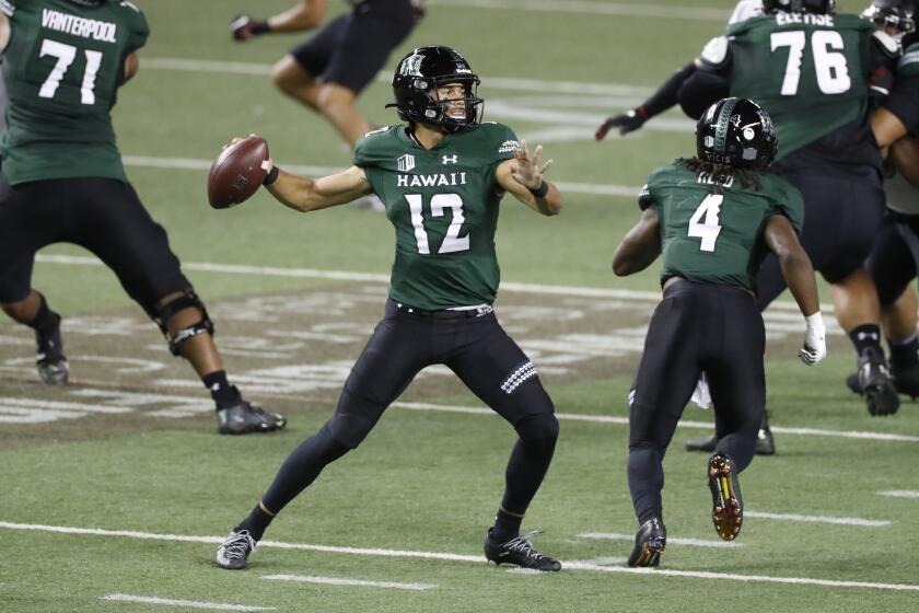 Hawaii quarterback Chevan Cordeiro (12) looks for a receiver during the first half against UNLV in an NCAA college football game Saturday, Dec. 12, 2020, in Honolulu. (AP Photo/Marco Garcia)