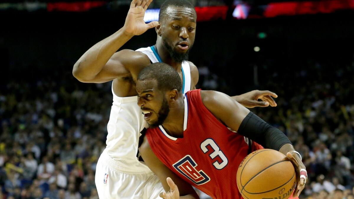 Clippers point guard Chris Paul (3) tries to drive past Hornets point guard Kemba Walker during their game Thursday in Shanghai.