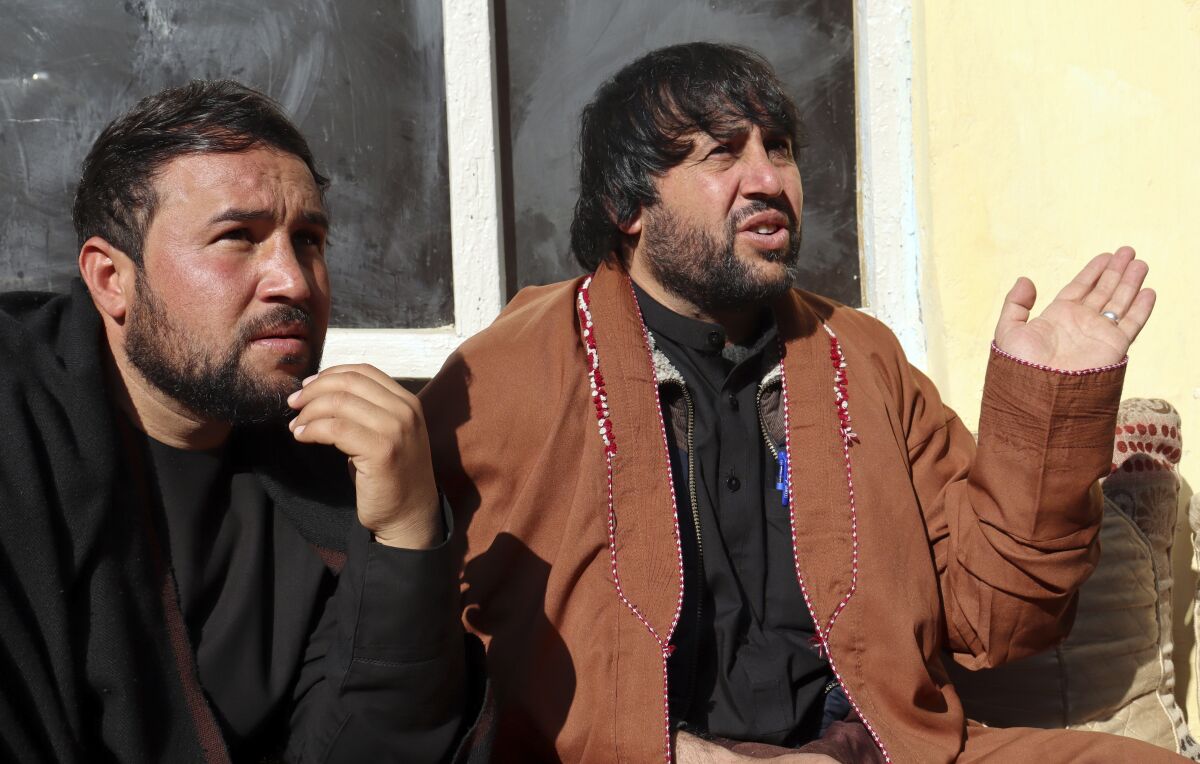Ajmal Ahmadi, right, a brother of Zemerai Ahmadi, who was one of ten family members who was killed in an errant U.S. drone strike in August, speaks during an interview with The Associated Press at the Ahmadi family home, in Kabul, Afghanistan, Tuesday, Dec. 14, 2021. The Afghan survivors of the U.S. drone strike said Tuesday they are frustrated and saddened by a decision that no U.S. troops involved in the strike would face disciplinary action. (AP Photo/Khwaja Tawfiq Sediqi)