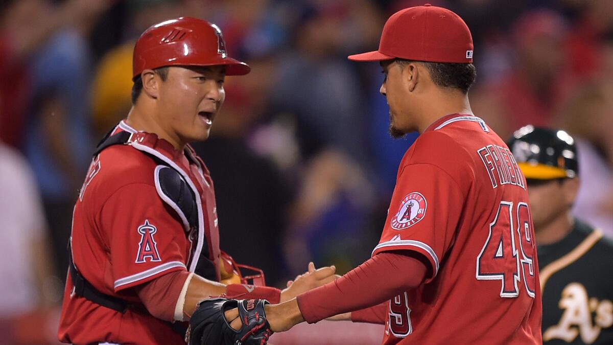 Angels catcher Hank Conger, left, congratulates closer Ernesto Frieri following the team's 4-1 win over the Oakland Athletics on Monday. The Angels managed to move closer to the Athletics at the top of the AL West following this week's series with Oakland.