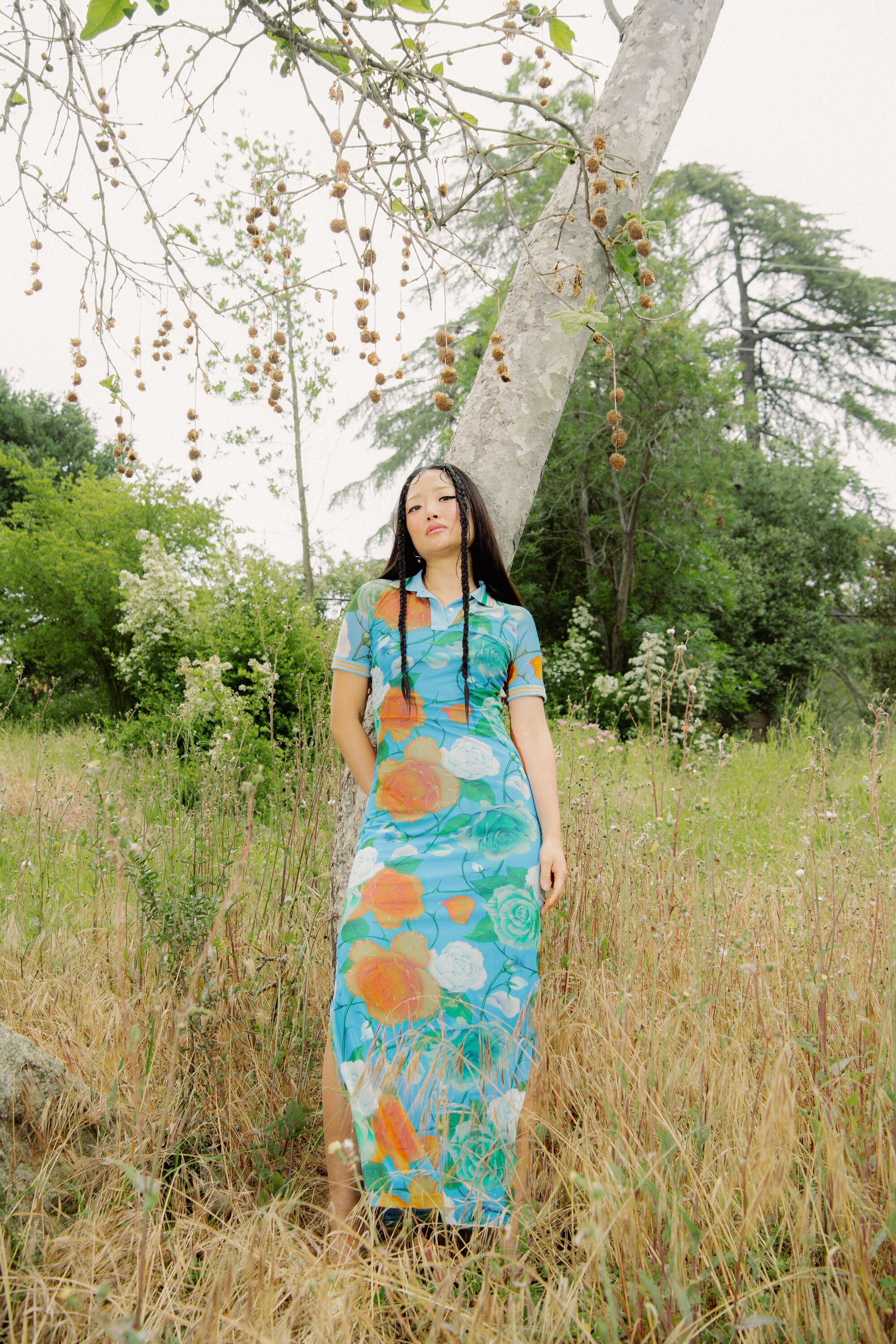 woman in skirt posing in front of a tree