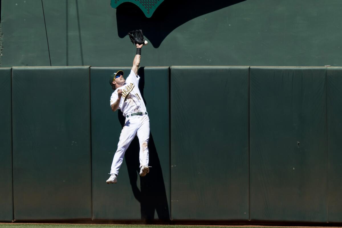 Oakland Athletics center fielder Skye Bolt misses a deep fly ball to allow a solo home run for Houston Astros' Kyle Tucker during the eighth inning of a baseball game in Oakland, Calif., Sunday, July 10, 2022. (AP Photo/John Hefti)