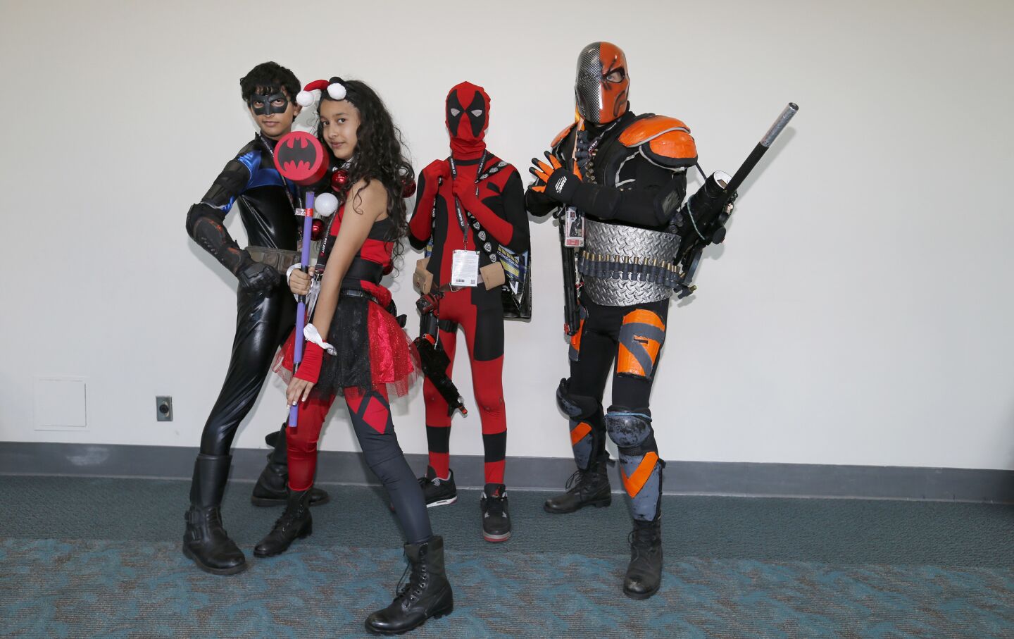 Patrick Meehan, right, of San Diego, dressed as DC comics character Deathstroke, and his children Chris Meehan, left; Charlotte Meehan, as Harley Quinn; and Ryan Meehan, as Spiderman; attend the preview night opener at Comic Con International 2017.