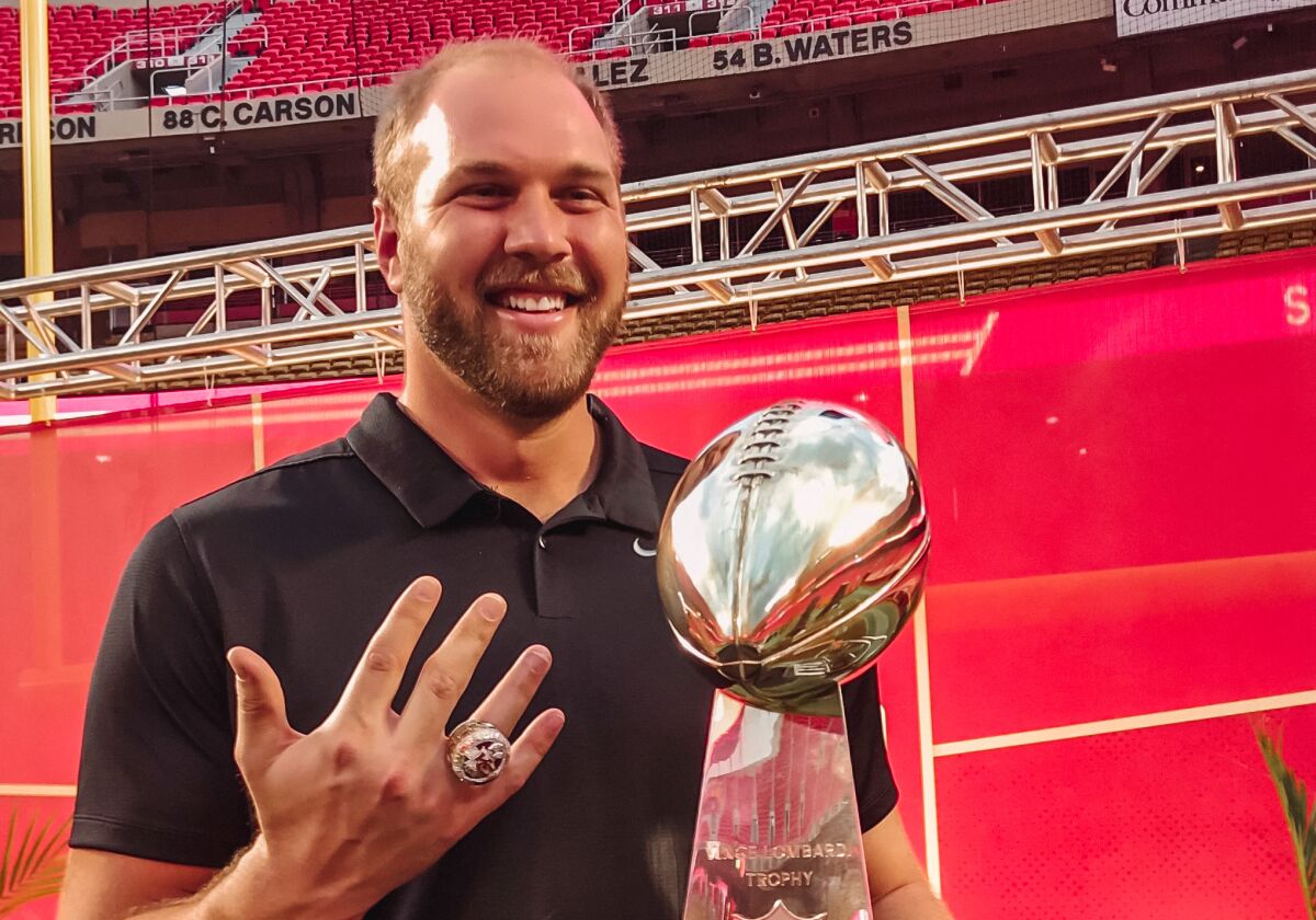 Mitchell Schwartz shows his championship ring as he poses with the Vince Lombardi Trophy.