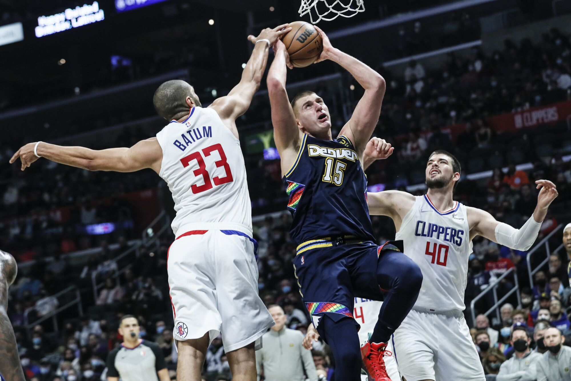 Clippers forward Nicolas Batum gets his fingertips on a layup attempt by Nuggets center Nikola Jokic.