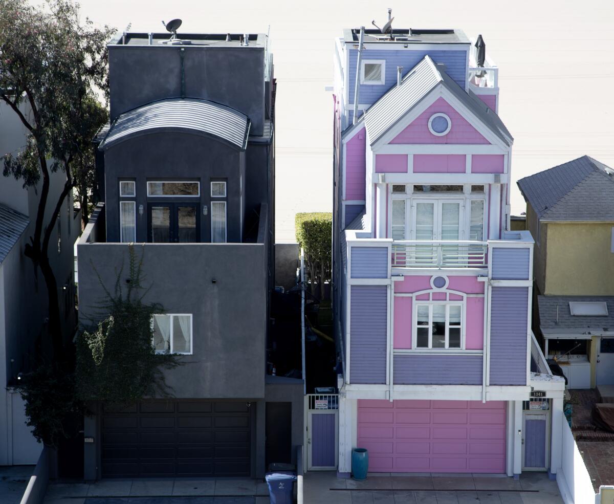 Two houses: the Barbie House, pink and purple, right, and the all-black house