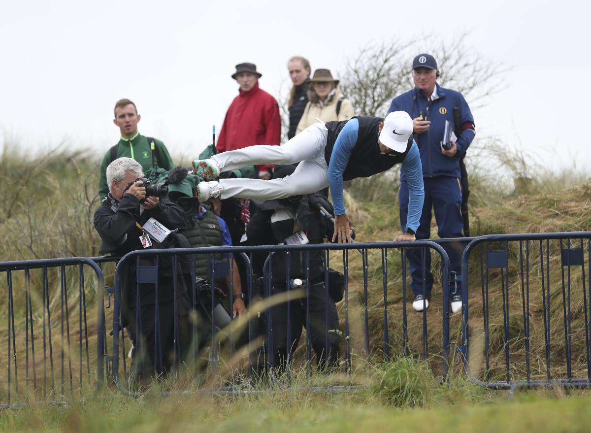 South Africa's Dylan Frittelli leaps over the metal railing as he searches for his ball on the 17th hole during the second round of the British Open at Royal Portrush in Northern Ireland.