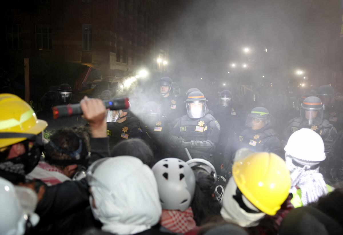 A protestor uses his flashlight on the police at the UCLA campus Thursday, May 2, 2024.