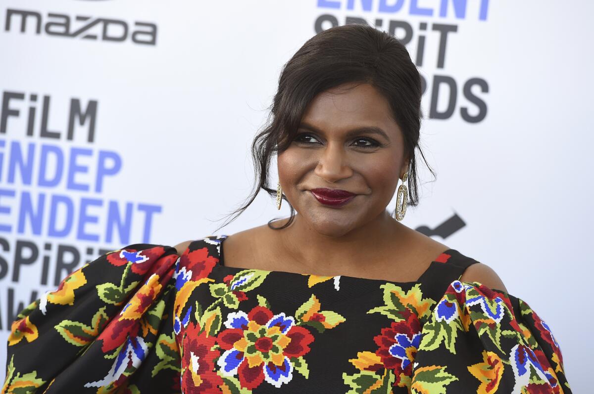 Mindy Kaling posing in a floral dress