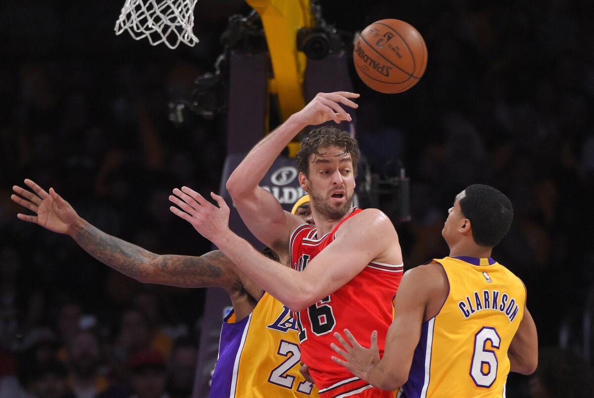 Bulls forward Pau Gasol flips a pass as he faces the double-team defense of Lakers center Jordan Hill (27) and guard Jordan Clarkson in the first half.