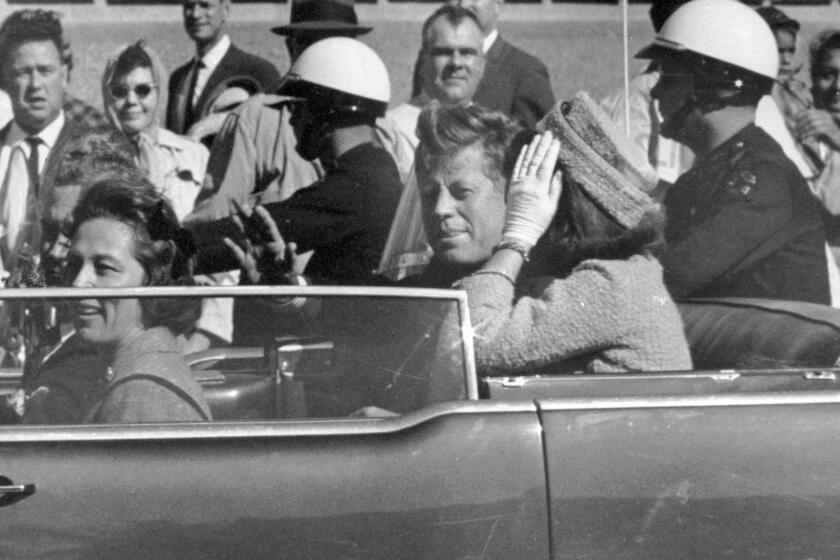 ARCHIVO - El presidente John F. Kennedy saluda desde su auto aproximadamente un minuto antes de que fuera baleado el 22 de noviembre de 1963, en Dallas. Lo acompañan su esposa Jacqueline Kennedy; el gobernador de Texas, John Connally, y la esposa de éste Nellie Connally. (AP Foto/Jim Altgens, Archivo)