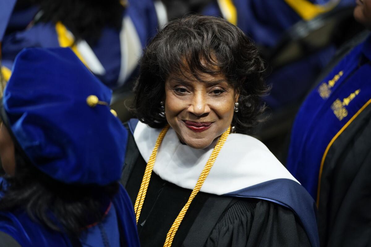 Phylicia Rashad smiles in a graduation gown with her hair styled in a curled bob.
